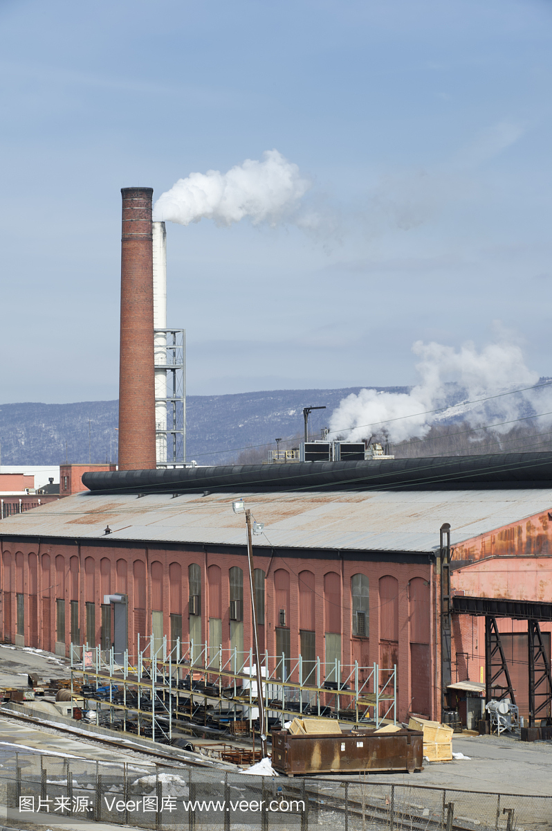 在陽(yáng)光下工作的工廠與煙囪排氣