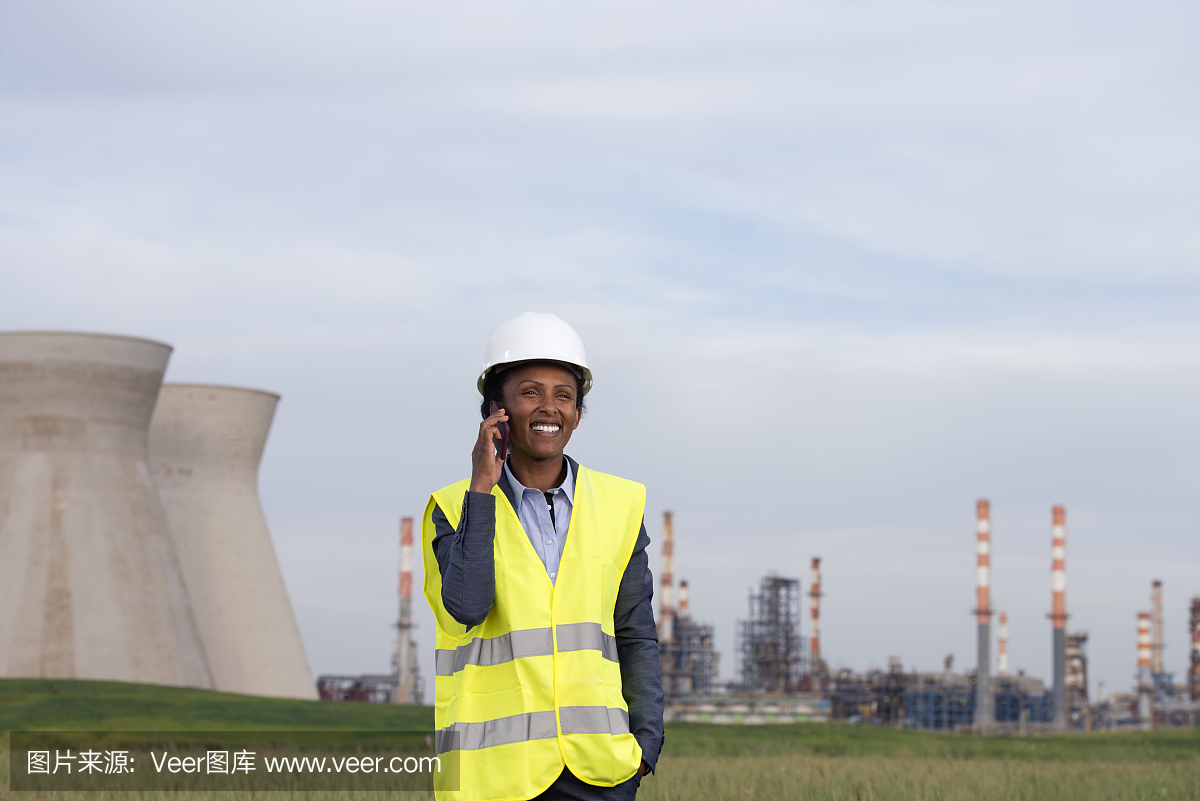 在化工廠打電話的女商人。